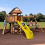 Canyon Creek Outdoor Kid's Playground Set w/ Rockwall, Upper Fort, Swing Set, Green Wave Slide, and PlaySet Kitchen - Peak w/ Yellow - Image 1